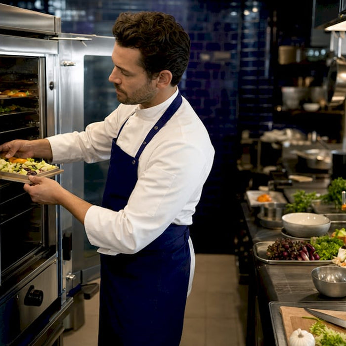 Chef placing trays in commercial steamer oven