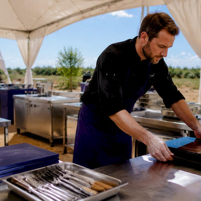 Chef arranging kitchen equipment in catering tent