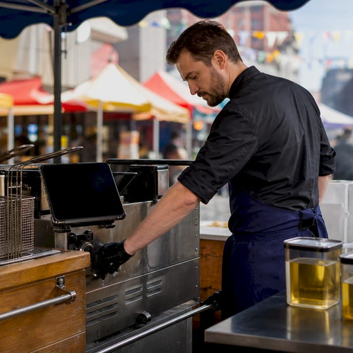 Caterer preparing portable fryer at outdoor event