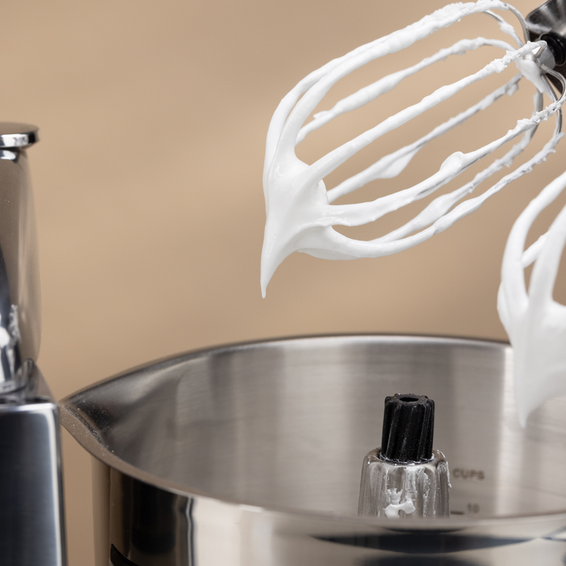 Balloon whisk with meringue in the stainless steel beater bowl