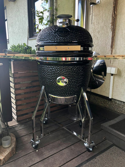 Black Kamado-style grill on a wooden deck